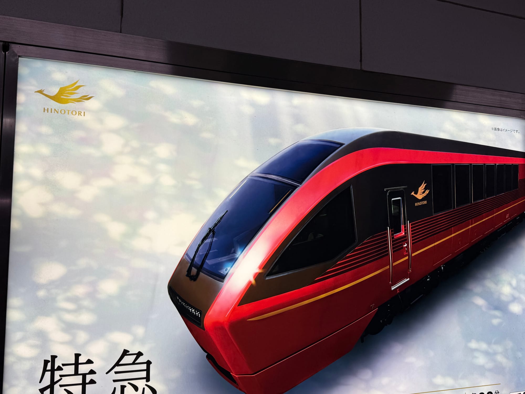 Advertisement for the Kintetsu Hinotori limited express train, featuring a large image of the streamlined red train and its distinctive gold phoenix emblem.