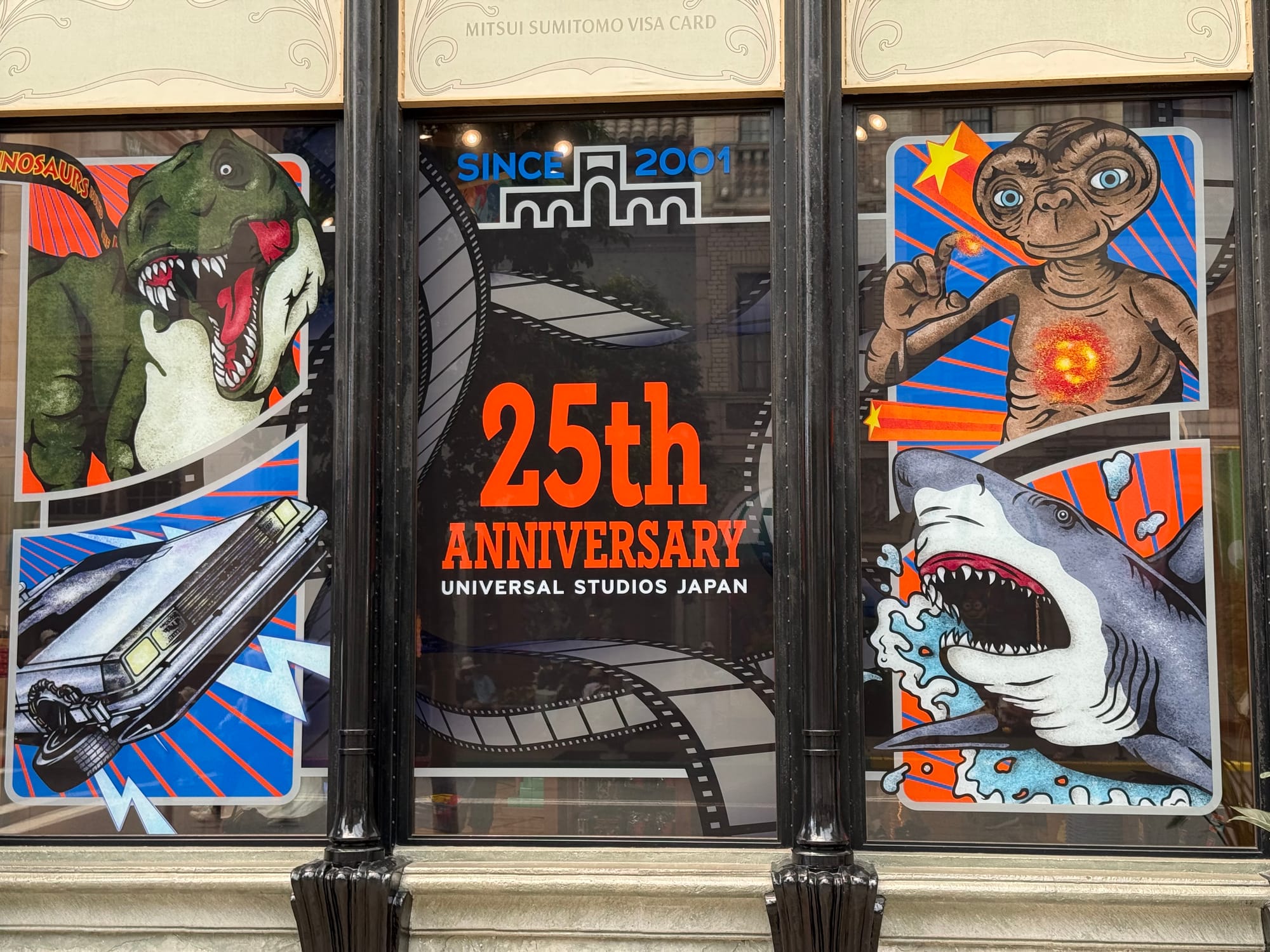 Universal Studios Japan 25th anniversary display featuring stylised illustrations of E.T., a Tyrannosaurus rex, a shark and the DeLorean time machine from Back to the Future.
