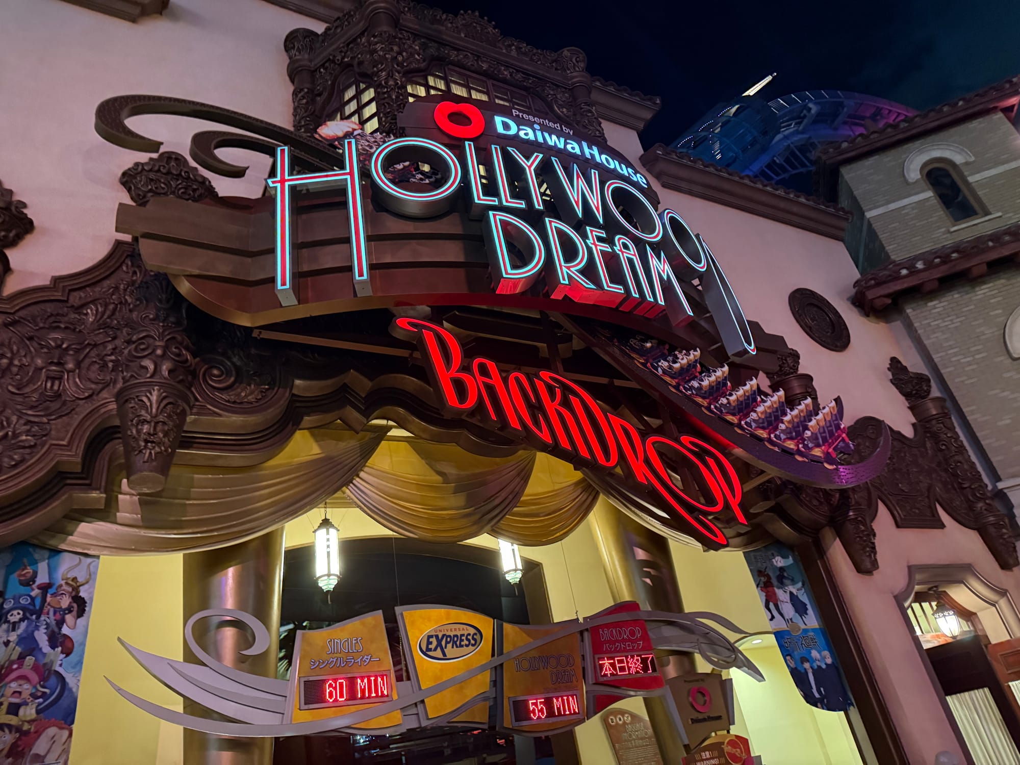 Entrance to Hollywood Dream: The Ride at Universal Studios Japan, featuring the illuminated attraction sign, Art Deco styling and queue time displays glowing after dark.