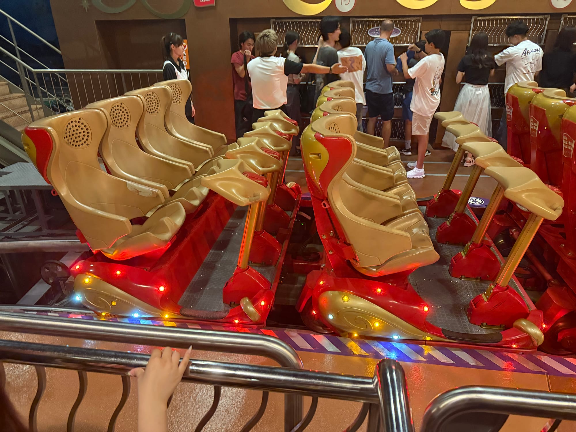 Loading platform for Hollywood Dream: The Ride Backdrop at Universal Studios Japan, showing backward-facing roller coaster trains illuminated with colourful lights before departure.