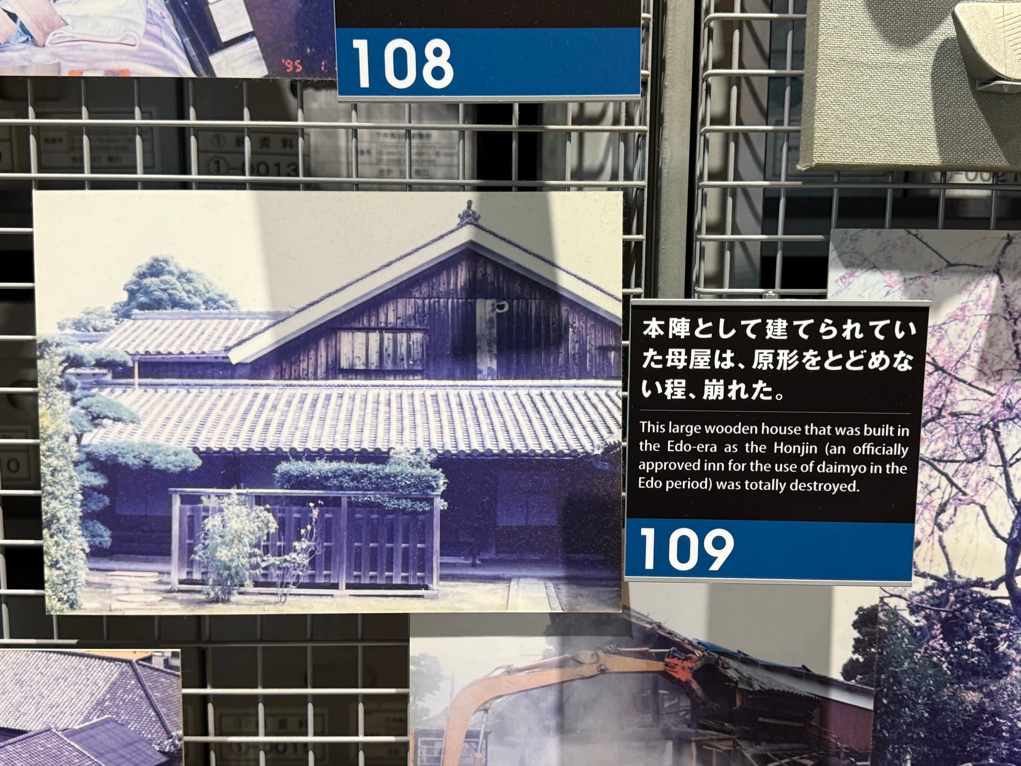 Museum panel at the Great Hanshin-Awaji Earthquake Memorial showing a historic wooden honjin building that collapsed during the 1995 earthquake, alongside explanatory text and photographs.