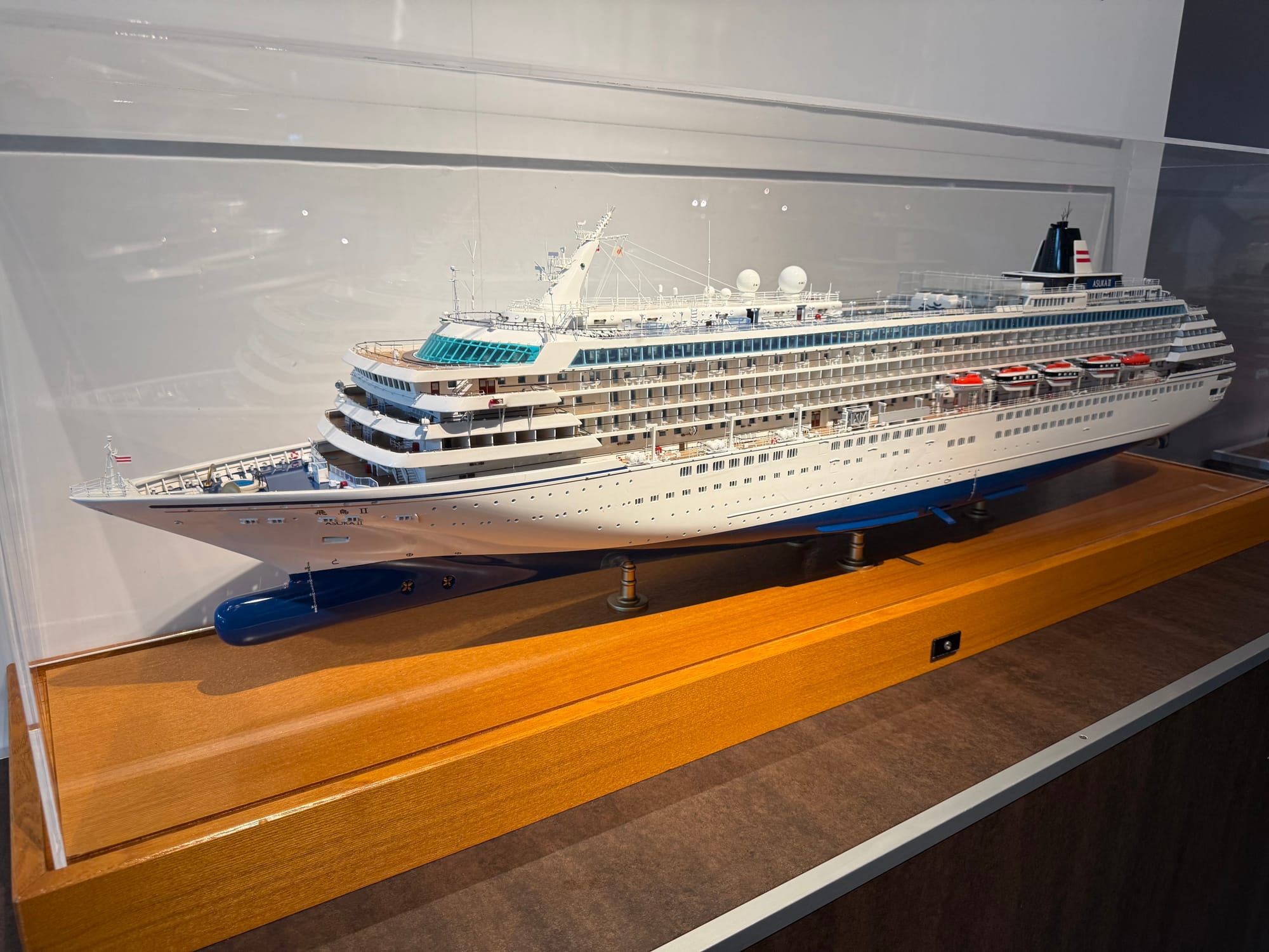 Scale model of the cruise ship Asuka II displayed at the Kobe Maritime Museum, showing the vessel's decks, lifeboats, bridge, funnels and detailed passenger facilities.