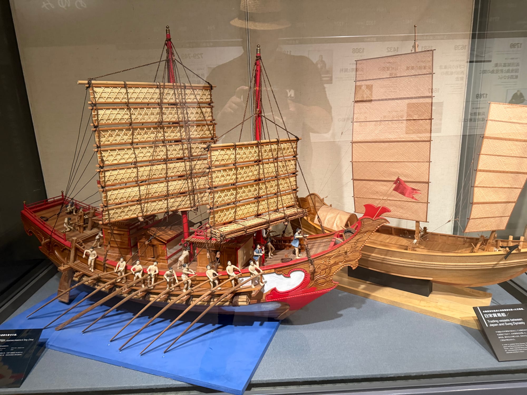Scale models of historic trading vessels displayed at the Kobe Maritime Museum, including an oared Chinese junk and a Japanese sailing ship used in regional trade routes.