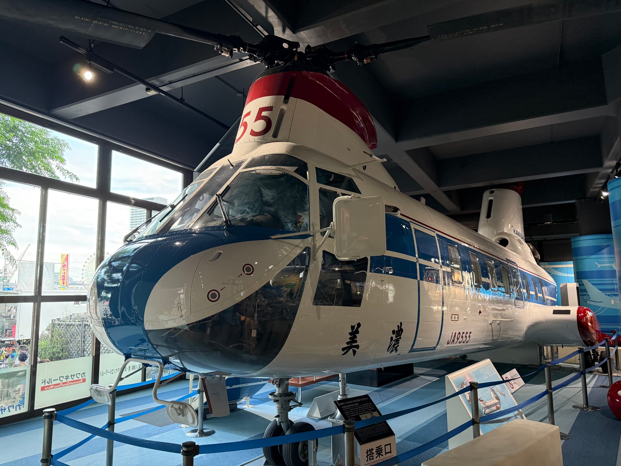 Kawasaki Vertol KV-107IIA-2 helicopter displayed at Kawasaki Good Times World in Kobe, featuring the blue-and-white livery and tandem-rotor design used for utility operations.