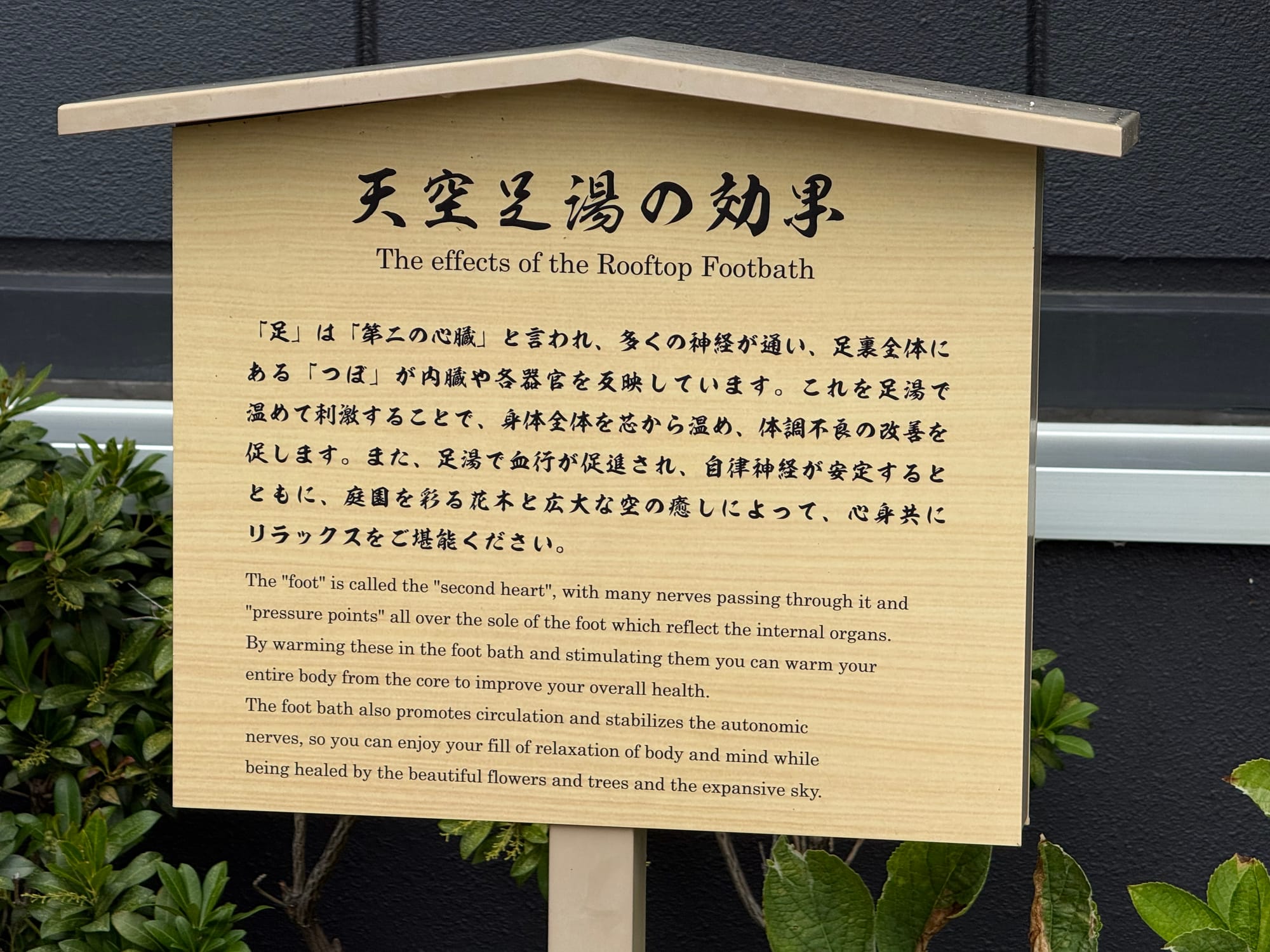 Information sign at Solaniwa Onsen Osaka Bay Tower explaining the benefits of the rooftop footbath, with Japanese and English text describing relaxation and circulation.