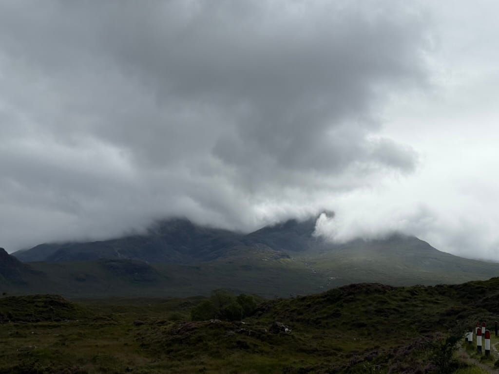 Misty mountains on the Isle of Skye beneath dark storm clouds.